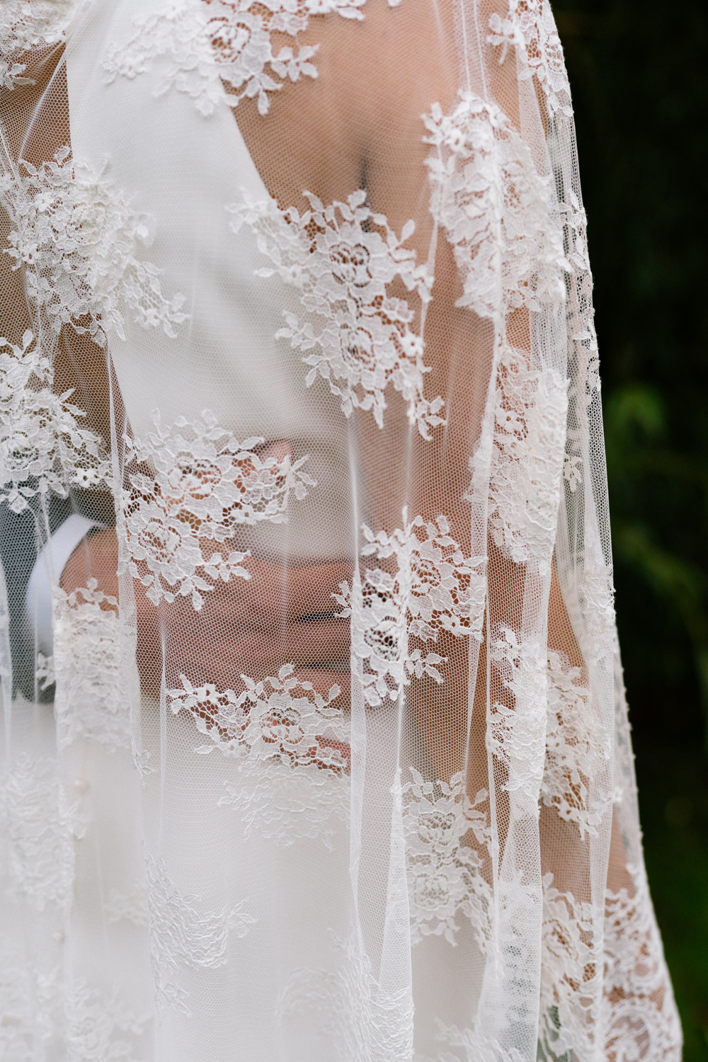 Marié qui tient sa femme par la taille, en dessous sa robe en dentelle