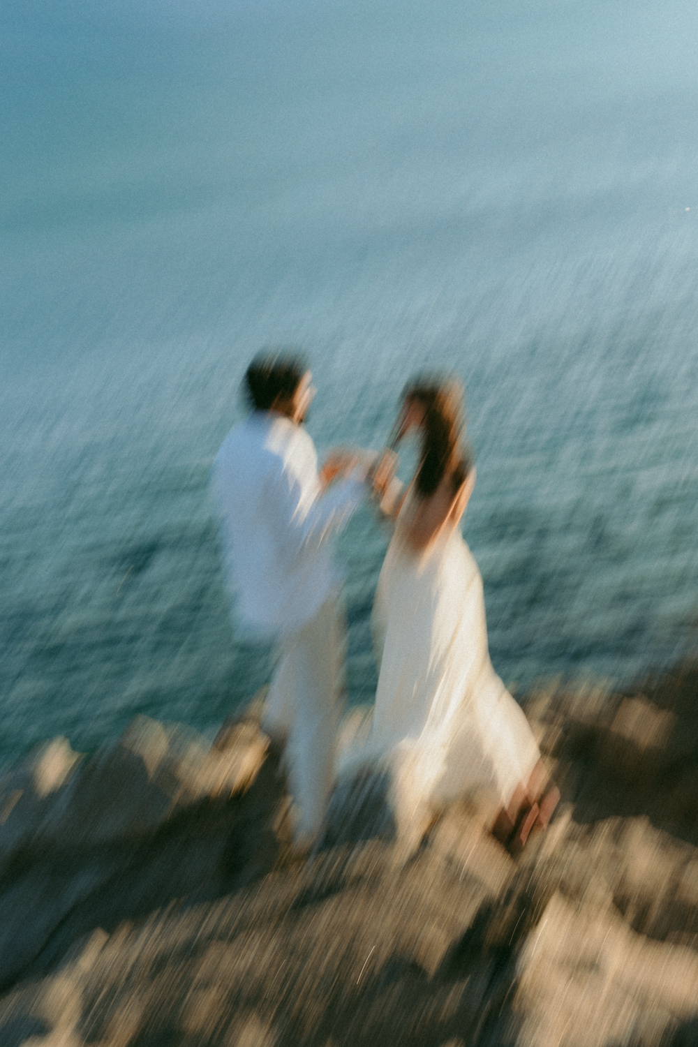 Couple sur les rochers en Bretagne qui joue avec leur main à Sainte-Marine dans le Finistère, flou artistique façon peinture