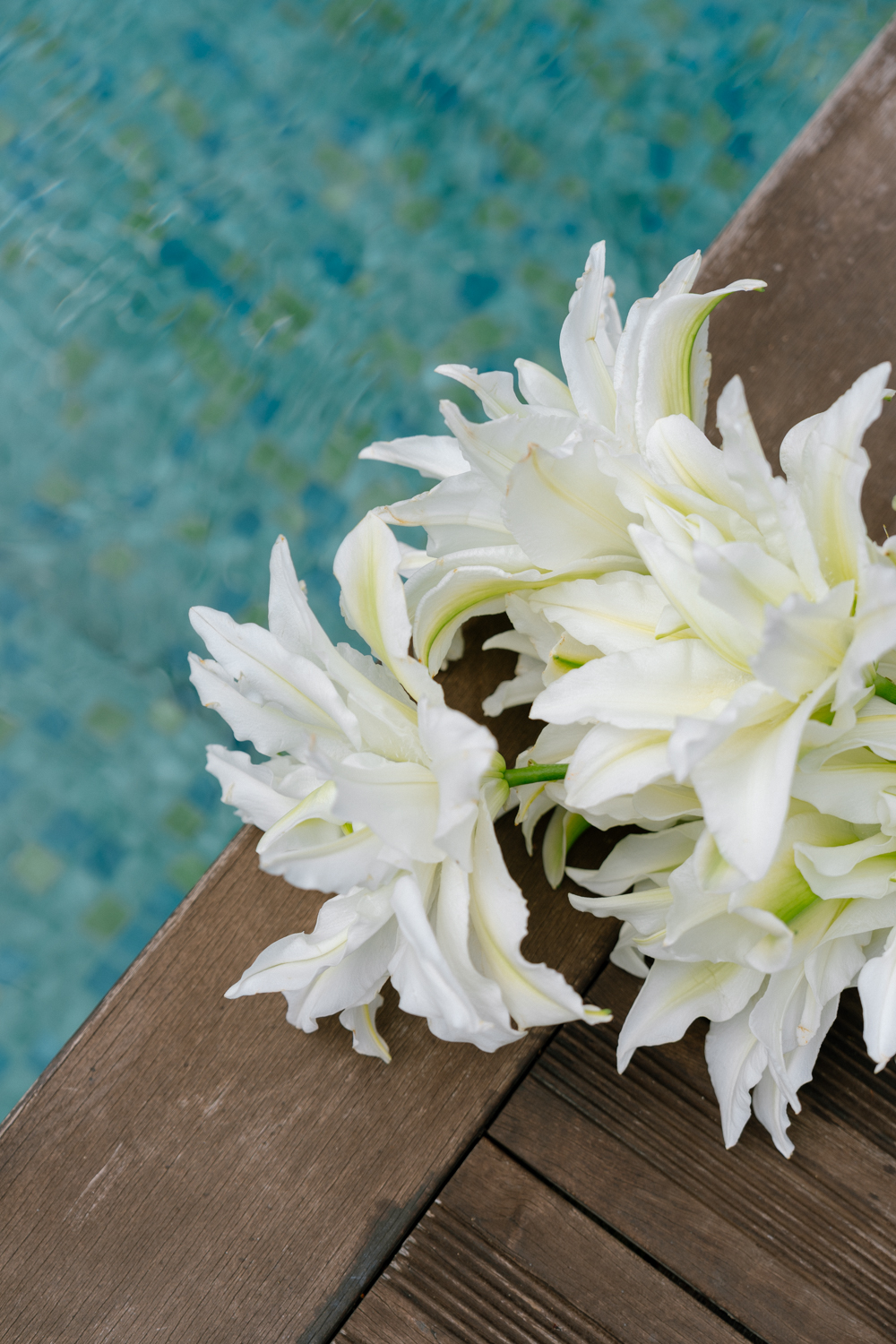 Bouquet de la mariée posée sur la terrasse près d'une piscine
