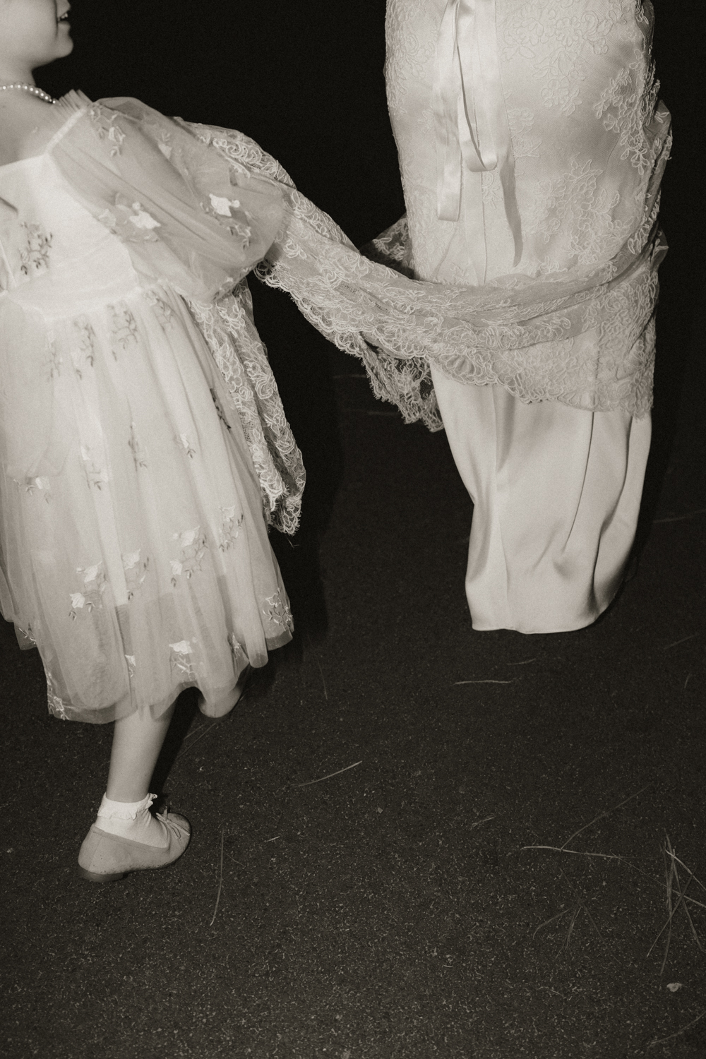 Petite fille qui tient la robe de la mariée