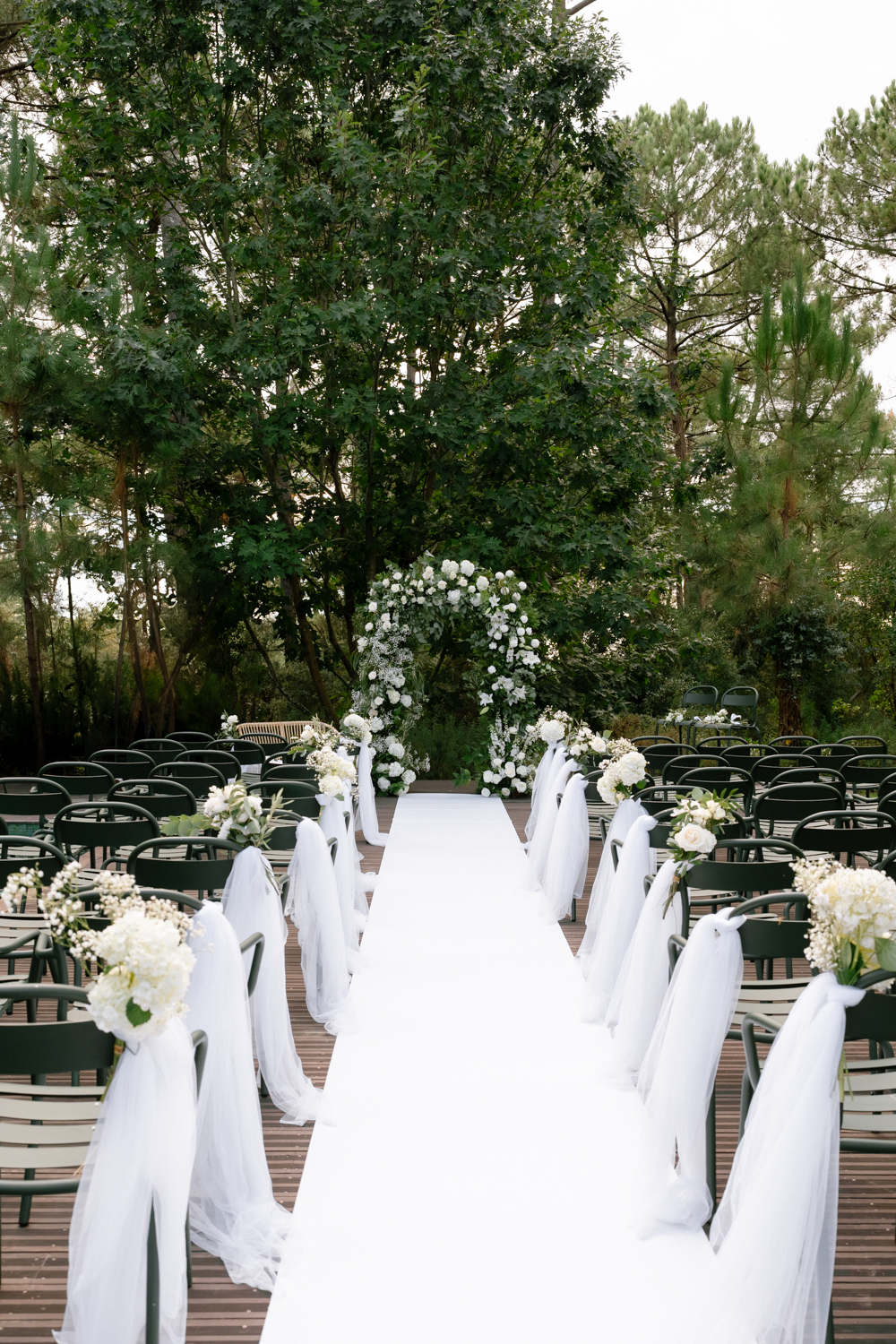 Scénographie d'une cérémonie laïque, un tapis blanc, une arche fleurie avec des fleurs blanches