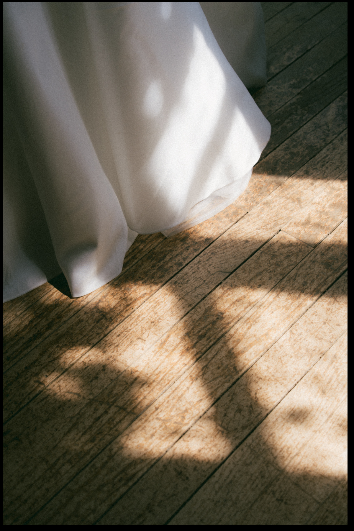 Robe de la mariée éclairée par la lumière avec l'ombre des arbres 