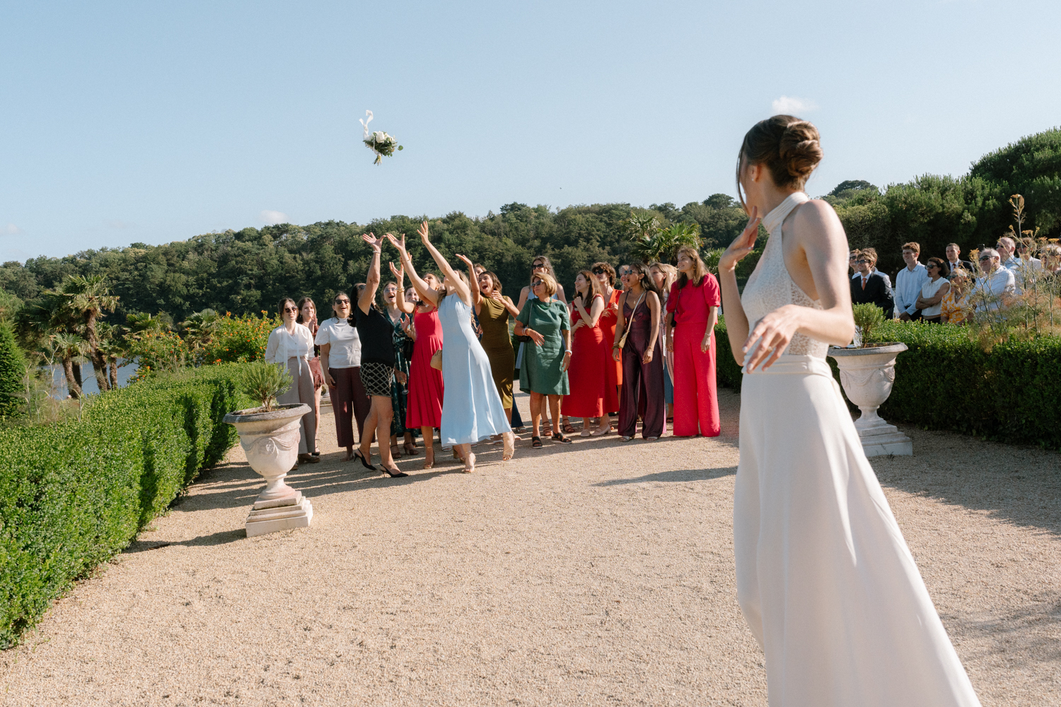 Mariée qui lance son bouquet à ses invitées